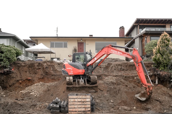 Excavator working on sewer line repair at residential property
